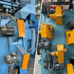 Side-by-side real comparison photo of a heavy-duty direct-drive blast wheel motor assembly next to a belt-drive shot blasting wheel with an enclosed pulley guard.