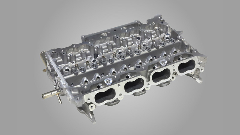 Precision sand cleanout on thin-walled automotive cylinder head casting via shot blasting.