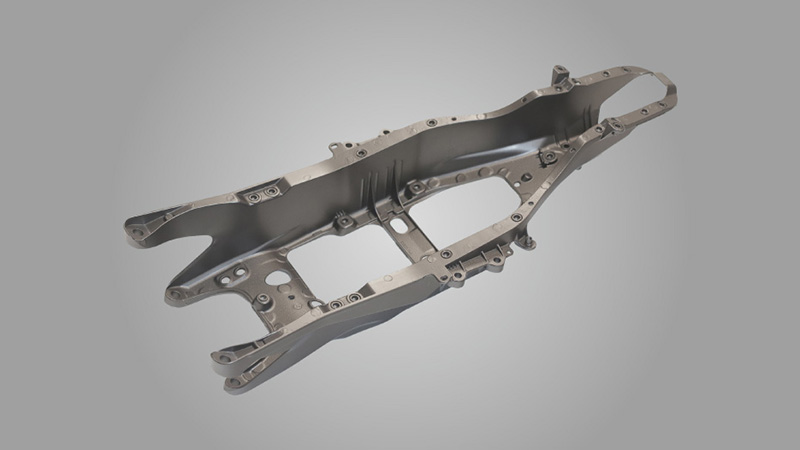 Die-cast aluminum rear control arm after automated shot blasting for deflashing and surface texturing.