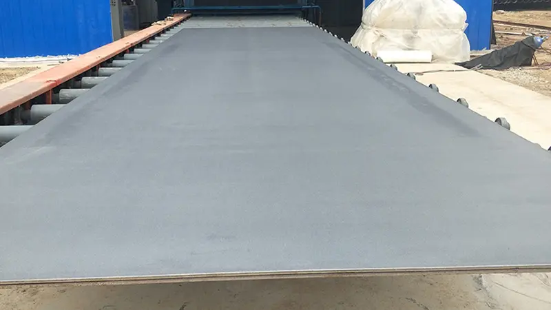 Shipbuilding & Marine Engineering 2 Blast-cleaned marine steel plate with uniform Sa 2.5 finish on a shipyard roller conveyor.