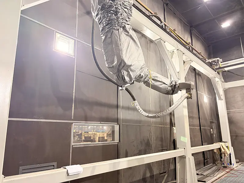 Overhead gantry rail track and heavy-duty travel carriage system supporting a suspended 6-axis blasting robot arm.