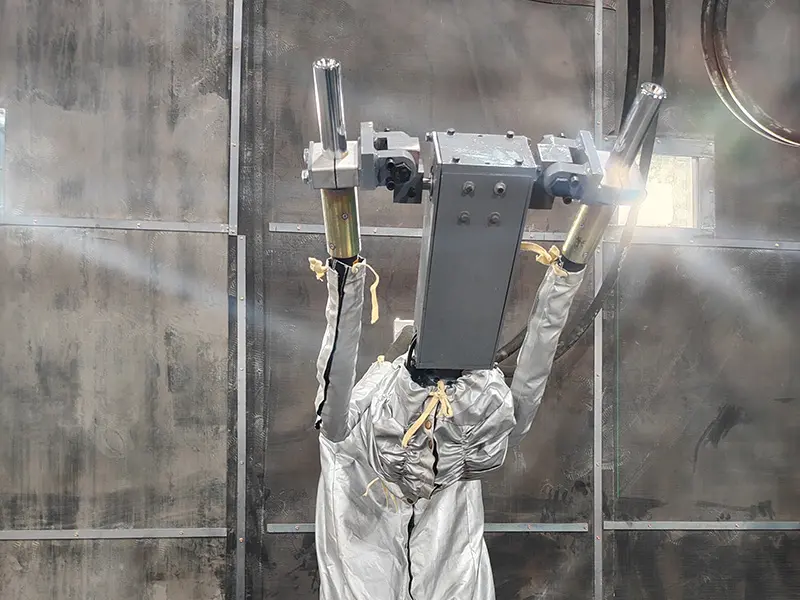 Detailed close-up of the dual-nozzle configuration mounted on the robotic blasting system arm for high-efficiency surface treatment.