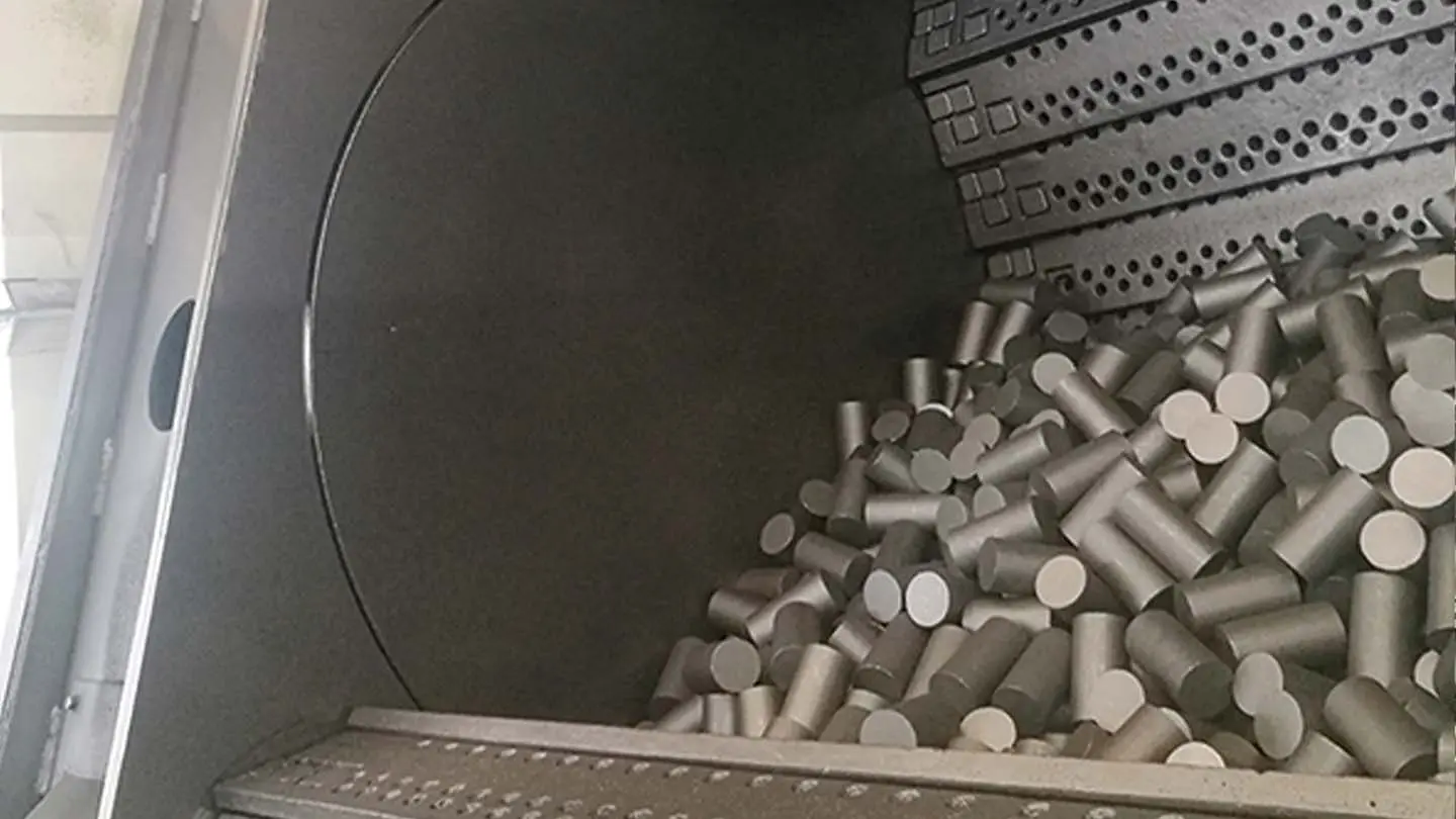 Inside chamber of tumble belt shot blasting machine with batch workpieces
